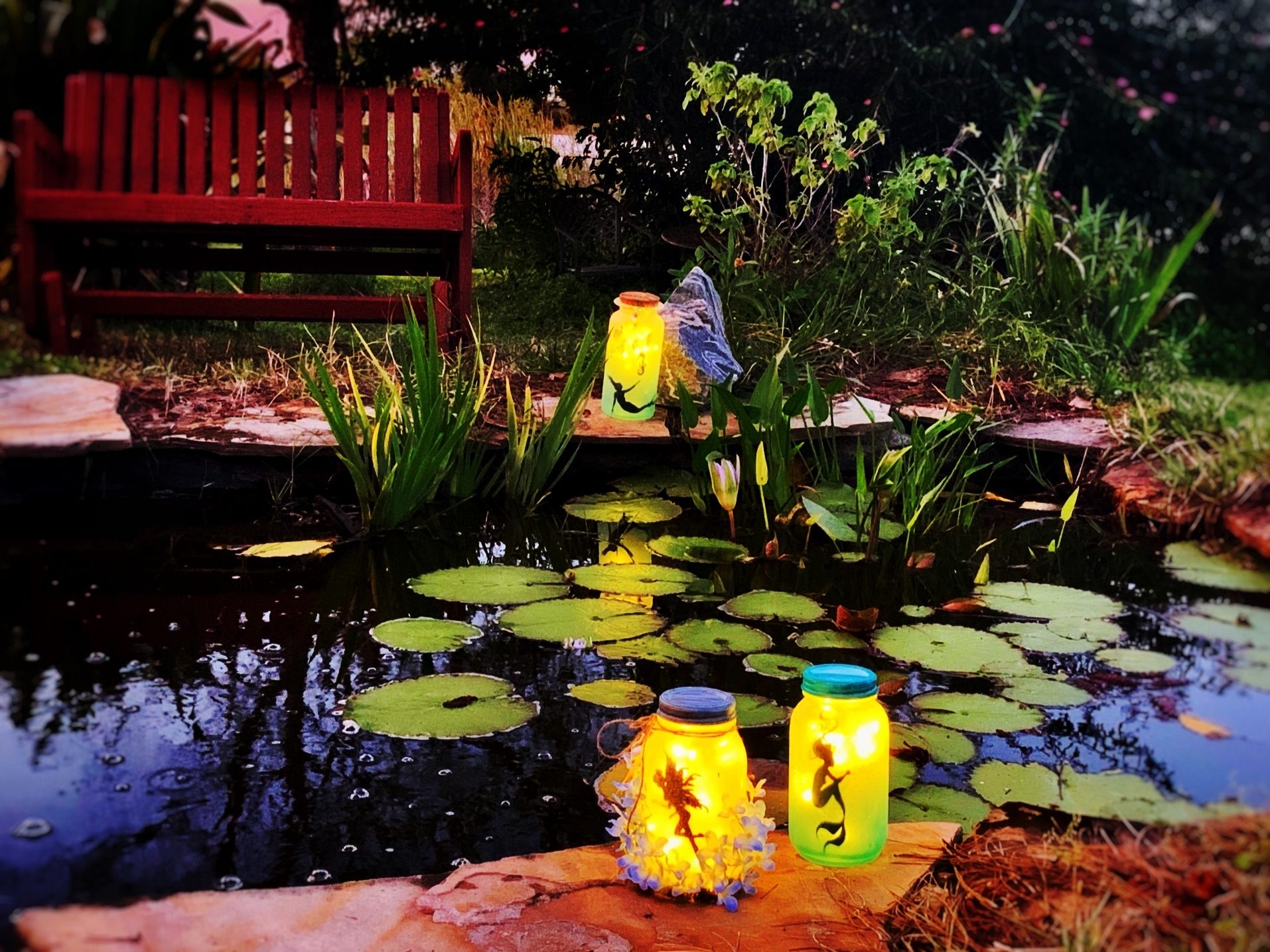 Luminaries around garden pond.