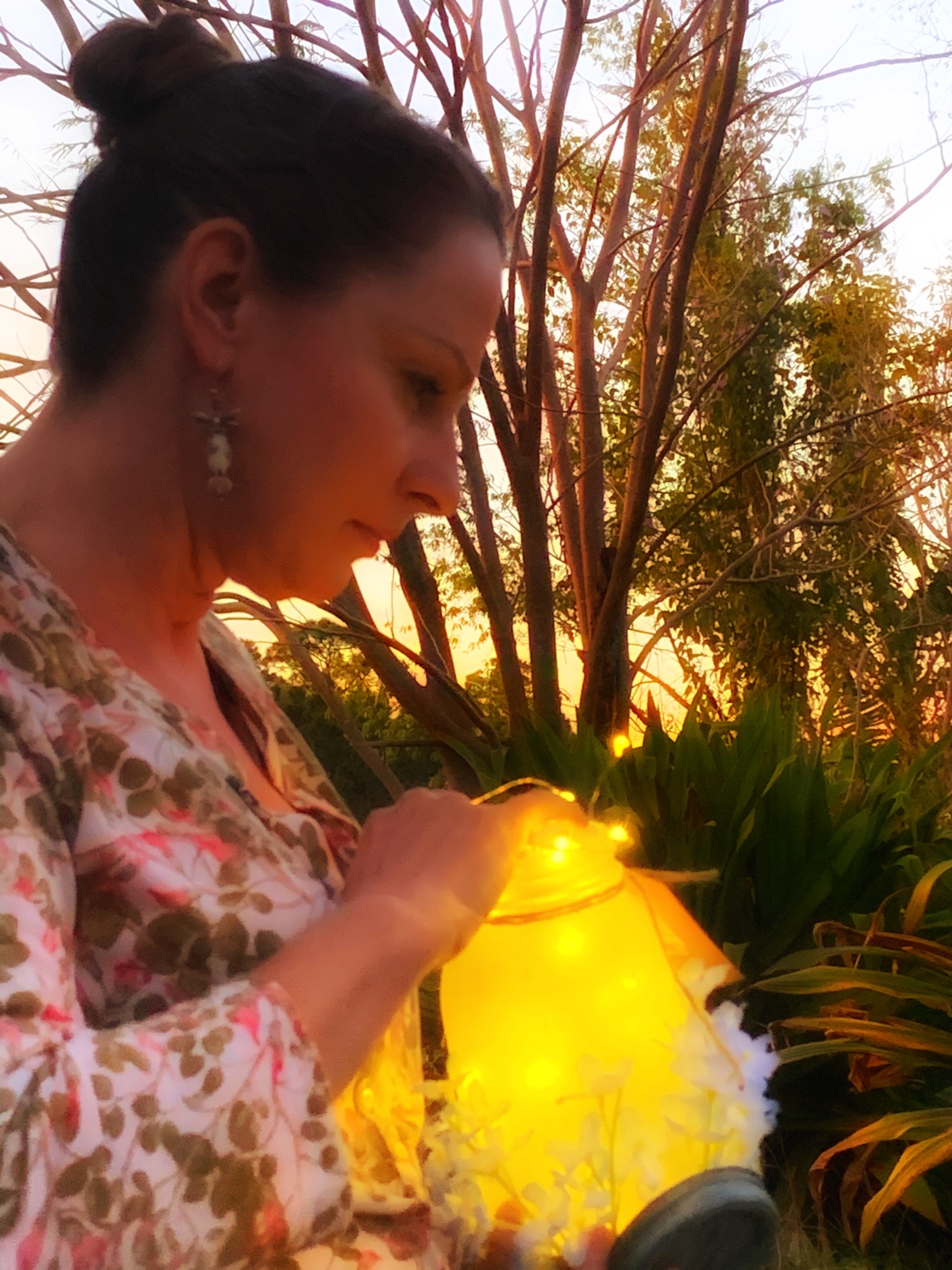 The artist placing lights in a luminary jar.